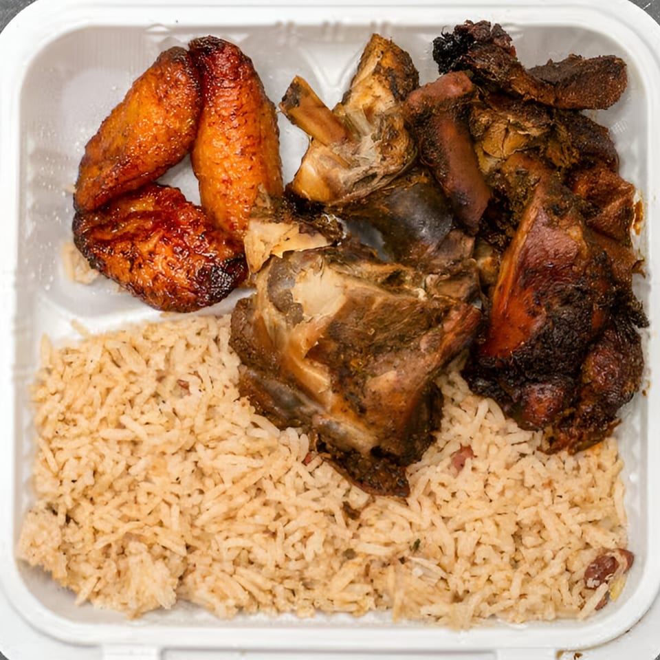 Jamaican oxtail and plantains with rice and peas in a white takeout container.