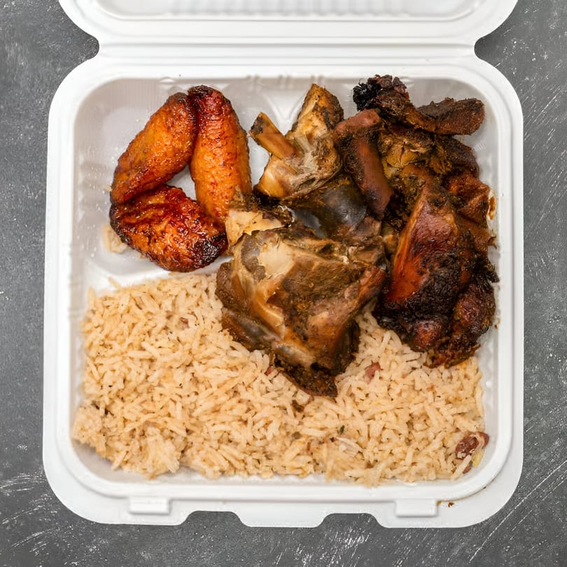 A Jamaican Way takeout container with rice and peas, stewed chicken, and fried plantains.