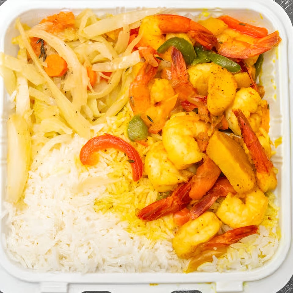 My Place Jamaica Way Restaurant's curried shrimp with white rice and sautéed vegetables.