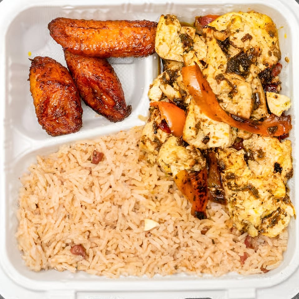 Jamaican jerk chicken with rice and peas, and fried plantains in a white takeout container.